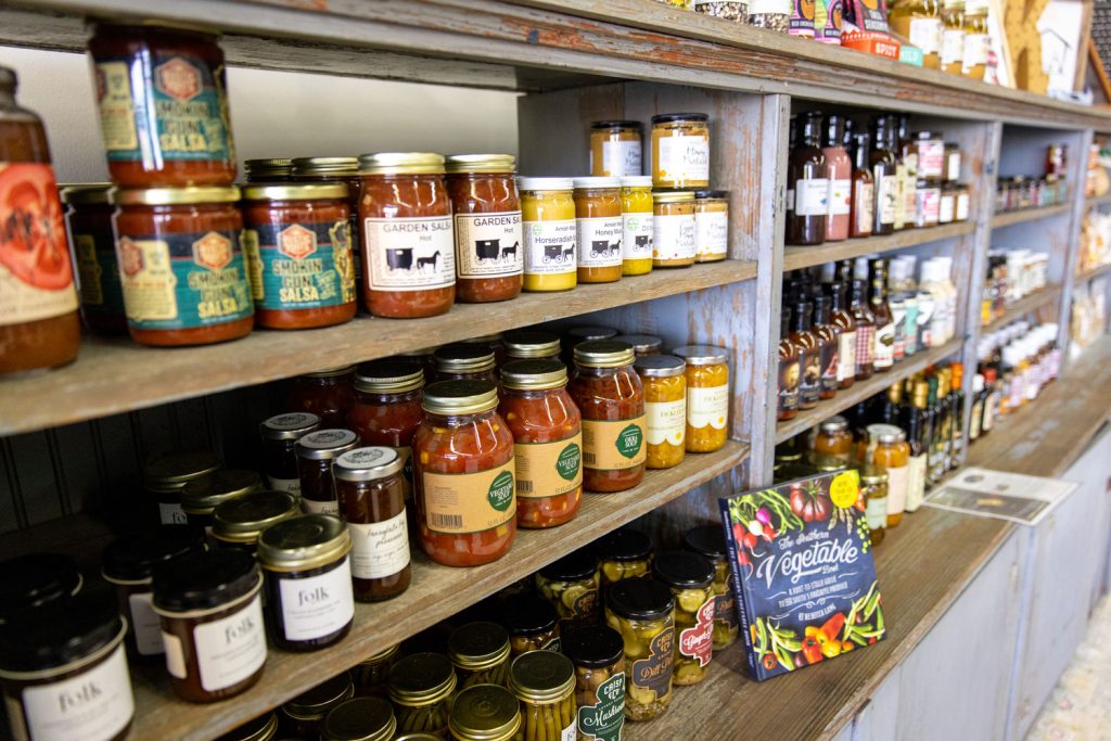 jars of salsas, dressings, and condiments on a shelf at the key farms meat and mercantile storefront on maple street
